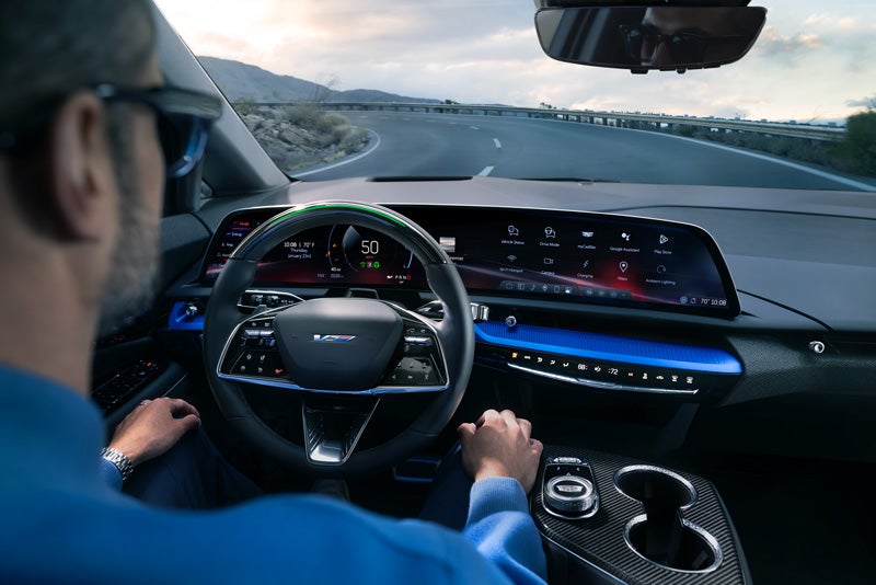 Front View of the 2026 OPTIQ-V Driving Through the Dusk Utilizing its Headlights | Joe Cooper Cadillac of Shawnee in Shawnee OK